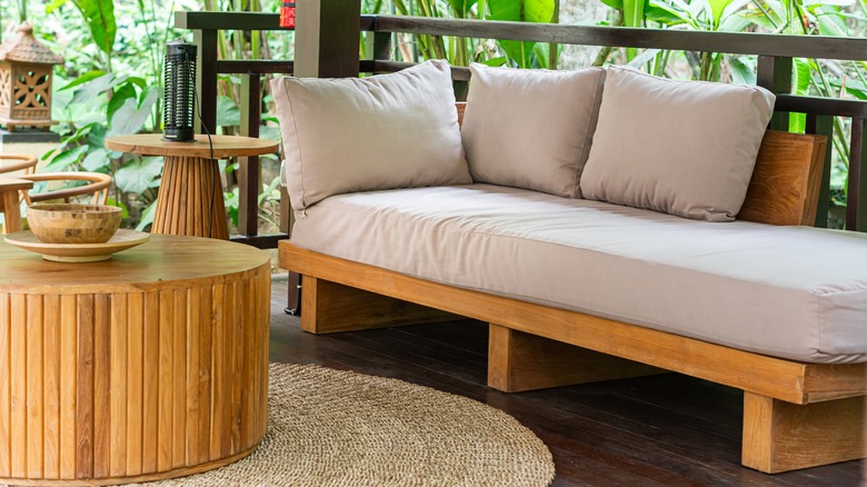 A cozy outdoor seating area with sofa, table, and rug