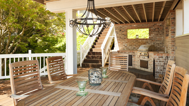 Covered outdoor dining area with outdoor kitchen in the corner