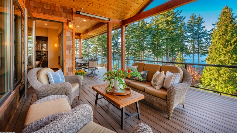 A wood deck with luxurious sofa and chairs