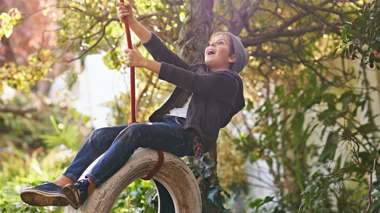 Boy playing on tire swing