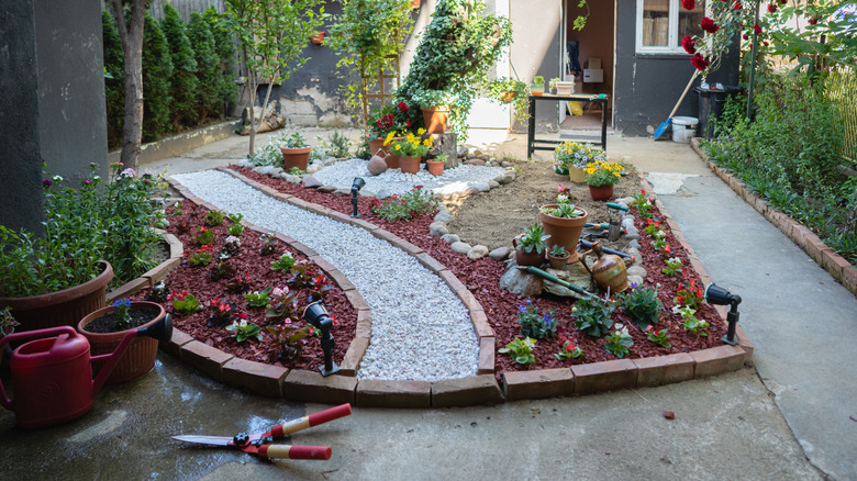brick edging with gravel and concrete paths in a small backyard
