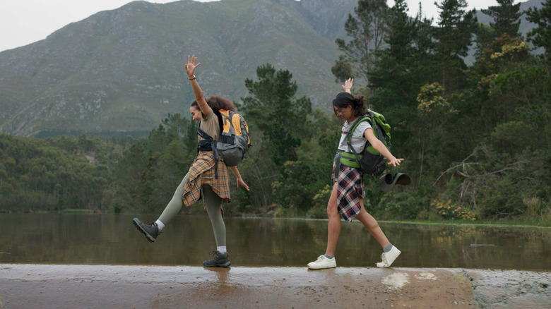 Two hikers balancing on ridge