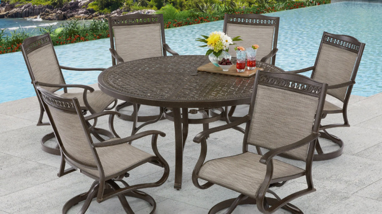 The Cullman 7-piece Sling outdoor patio dining set from Agio on a patio with a pool in the background