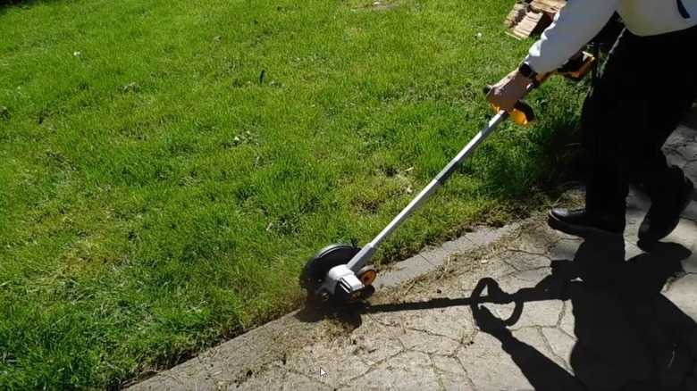 Man using a DeWalt Edger and cutting along a walkway