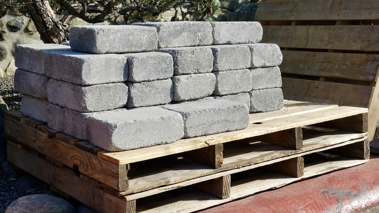 A stack of pavers on a palette with trees in the background