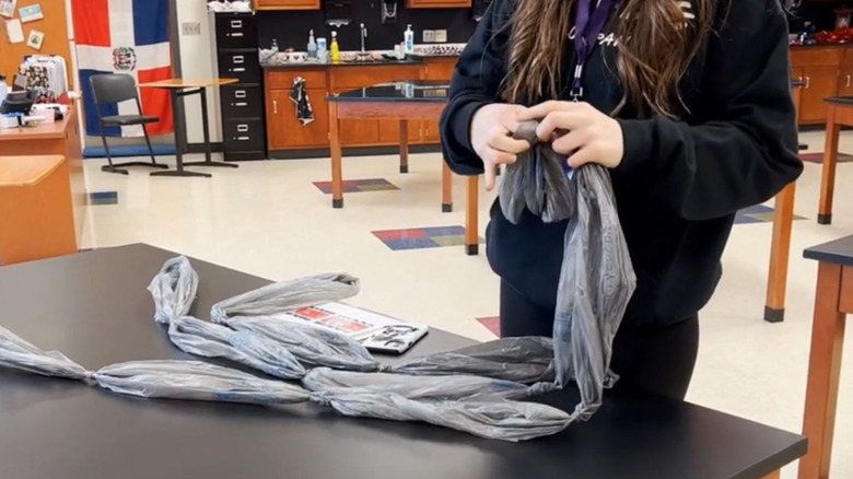 Someone creating braided ropes from plastic grocery bags