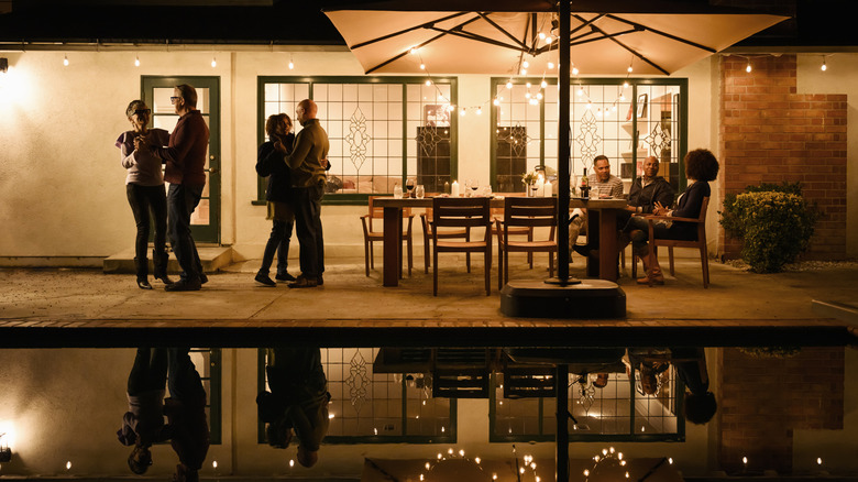 Family and friends enjoying a night on the patio, surrounded by string lights