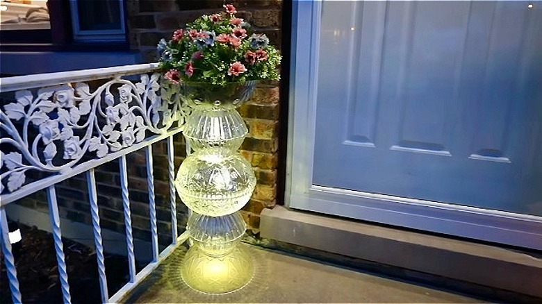 DIY light-up solar plant stand outside of a home at night