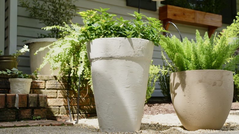 Faux stone plant pots in front of a house