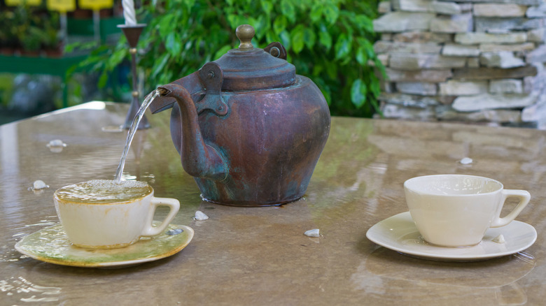 A teapot fountain pouring water into a cup