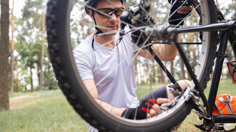 Cyclist fixing a flat tire in the field