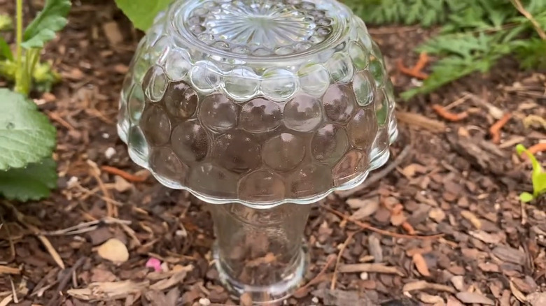 Mushroom sculpture made of glass bowl, vase, and fairy lights