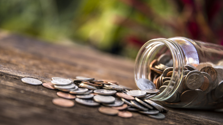 Coins spilling out of jar outside