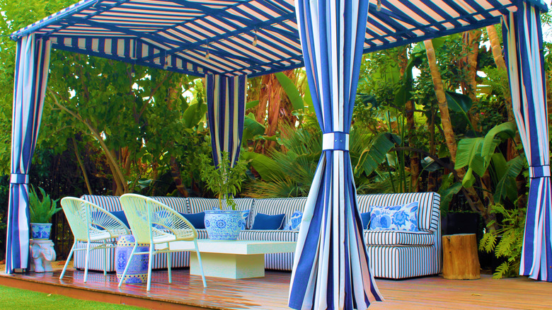 A garden deck with cabana cover and curtains
