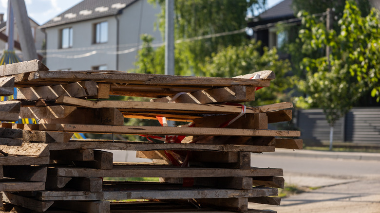 Pallets piled on a curb in a residential area.