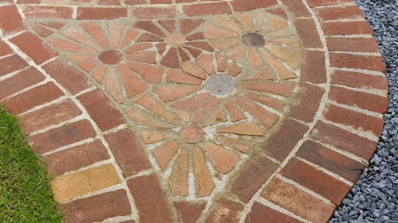 A brick mosaic path with a flower design