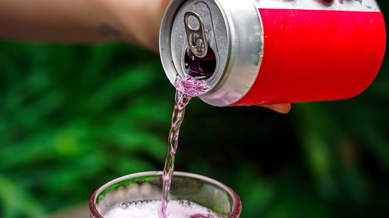close-up of a hand emptying a soda can