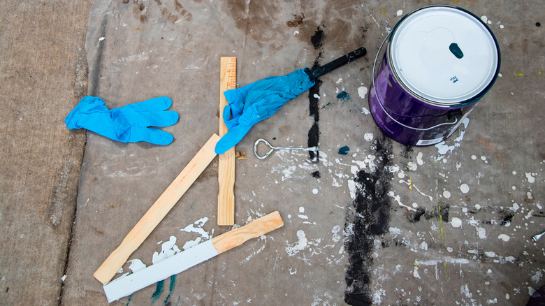 A paint can and extra stir sticks on a deck