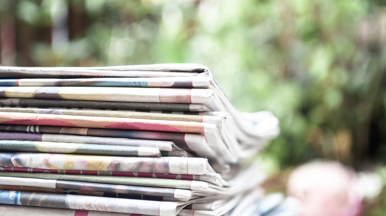 stack of newspapers with outdoor background