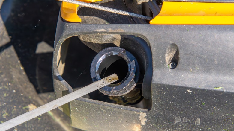 Dip stick next to mower's oil reservoir