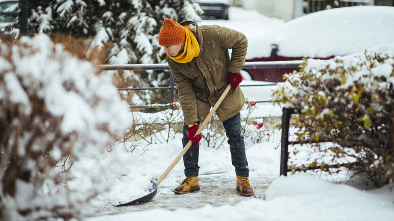 Man shoveling snow during in driveway