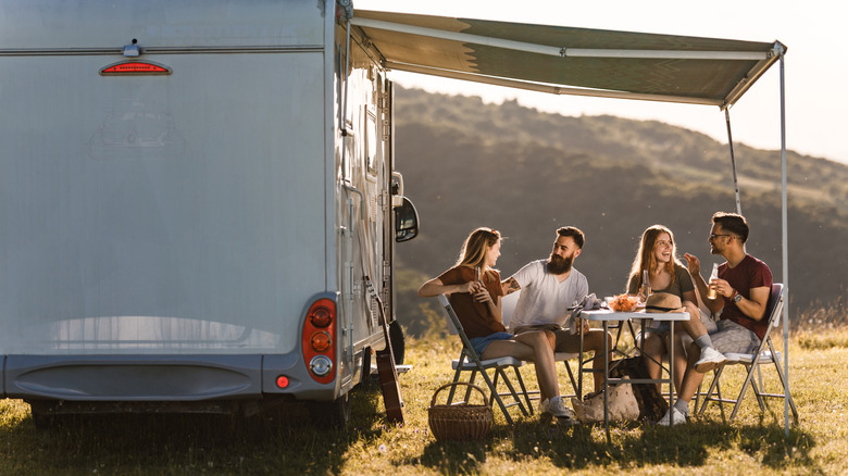 Campers at a picnic table by RV