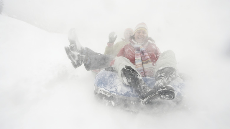 Women riding a snow tube