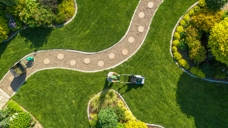 Aerial view of yard with man mowing lawn