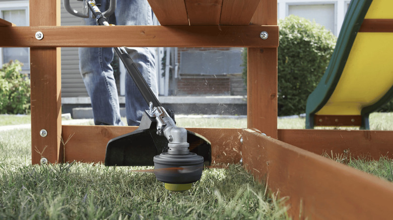 Ryobi gas trimmer navigating outdoor jungle gym