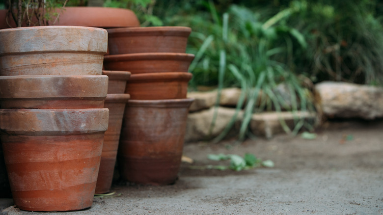 Stacks of aged terracotta pots on a patio