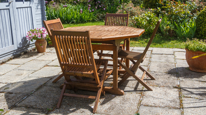 Wooden table and chairs set up on a garden patio