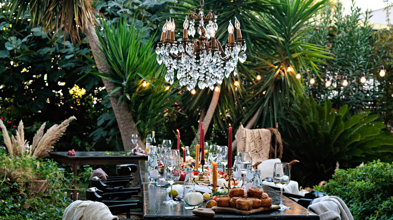 Outdoor dining table with chandelier above
