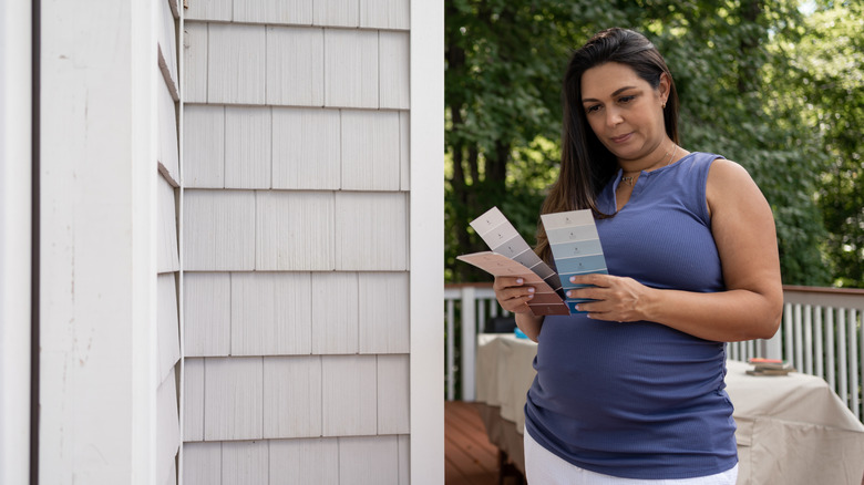 Woman holding an array of color swatches on patio