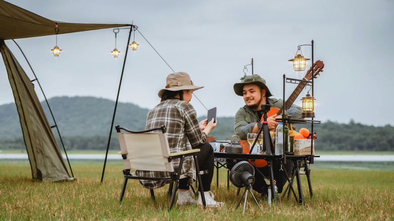 People camping in a meadow near a mountain