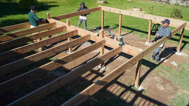 men building a deck out of pressure-treated lumber