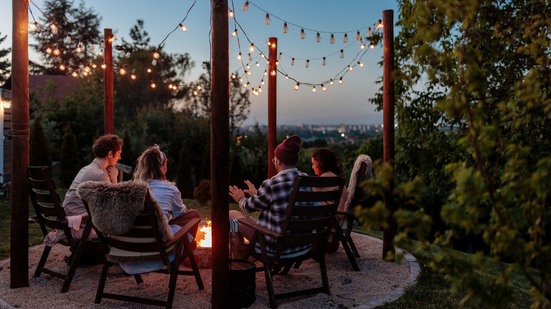 friends gather in backyard with view and fire pit