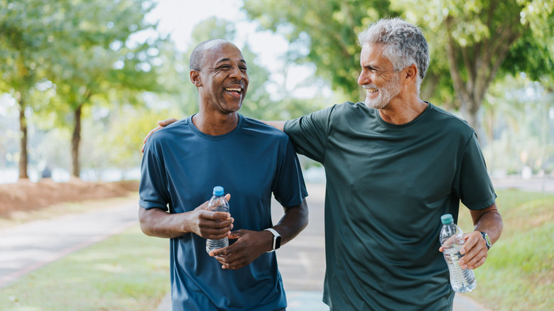 Two men walking with water bottles