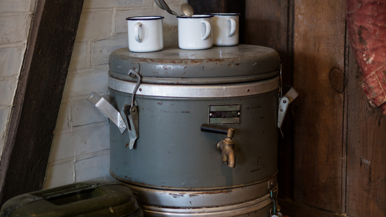 Vintage water cooler and enameled metal camp cups