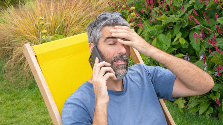Frustrated man on the phone in his backyard