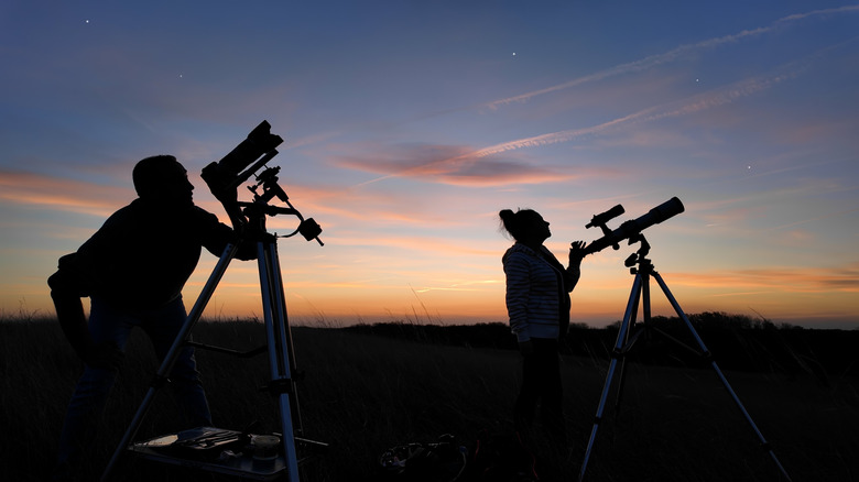 Stargazers preparing to view the night sky using telescopes