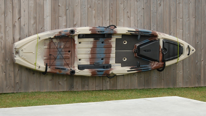 Kayak hanging on fence in yard