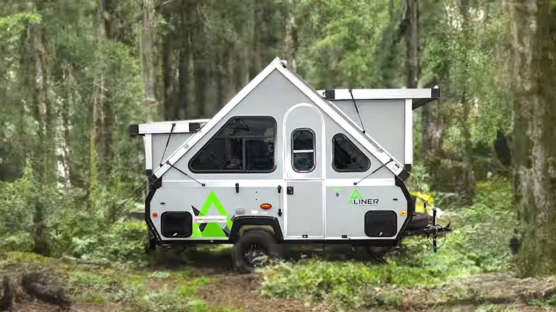 Aliner pop up camper set up in the woods