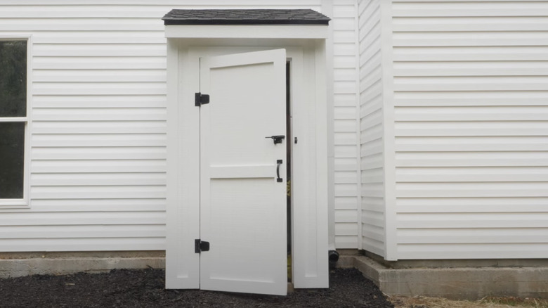 A small white shed with black hardware