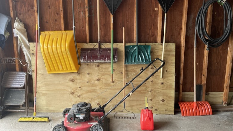 Inside of a shed with push mower and other tools