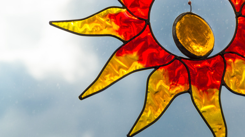 small stained glass birds lined up outside on brick