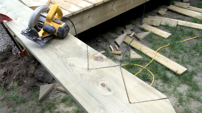 circular saw and staircase stringer getting cut in a backyard