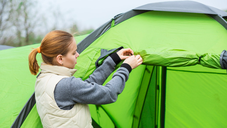 Person setting up tent