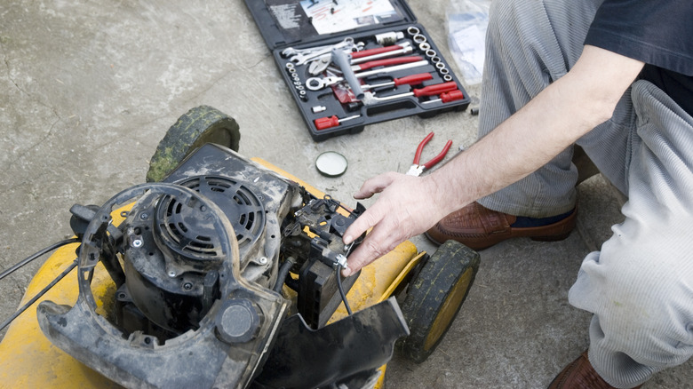 Someone repairing a lawn mower motor