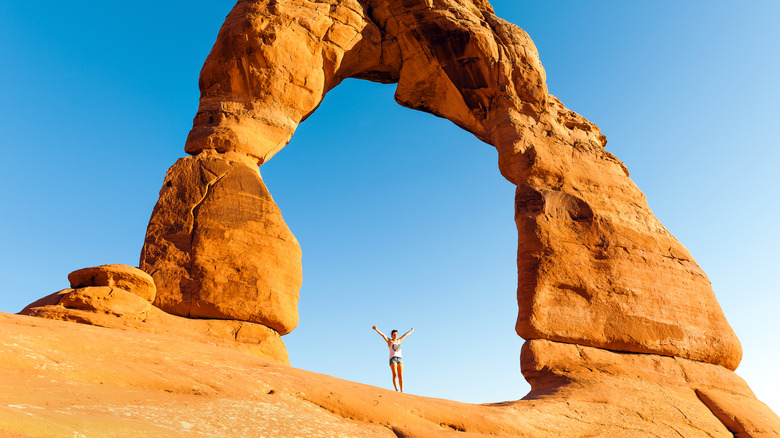 Woman standing under arch at national park
