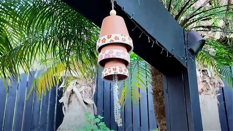 Terracotta wind chime hanging by house window